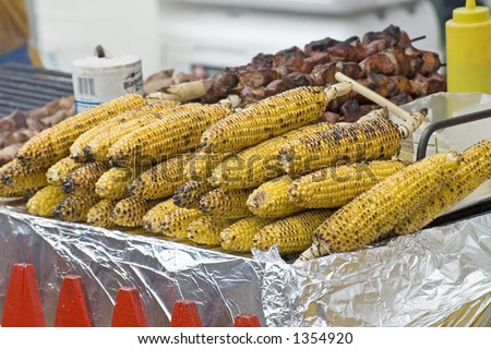 Corn roasted on a grill at a food stand on 9th Ave in New York City during a food festival.