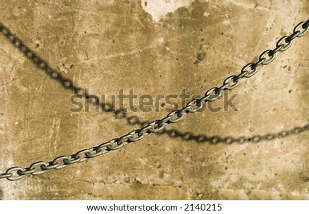 A chain and its shadow projected on a concrete wall.