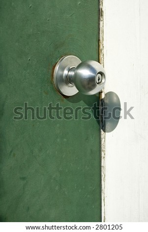 chrome door knob on a green door.