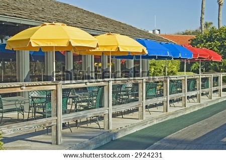 Four opened umbrellas at a club house on a golf course in Ponte Vedra Florida.
