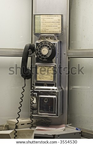Old rotary phone in a phone booth.