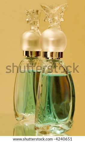 Cut glass bottle with green liquid reflected in a mirror.