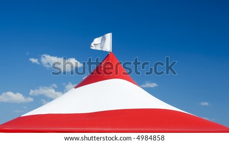 Red and white striped tent with a white flag.