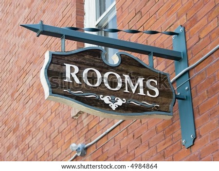 Room sign hanging on a red brick wall.