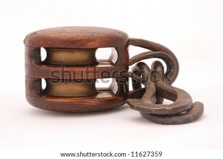 A vintage brown metal and wooden ship tool, called block, isolated on white background