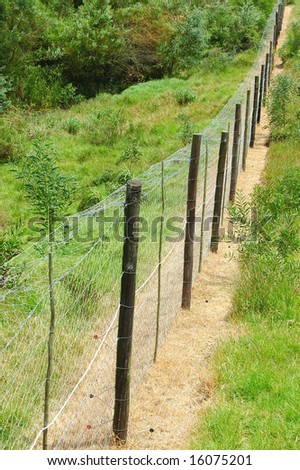 A high and wide electrical fence to protect people from wild animals in a game reserve in South Africa