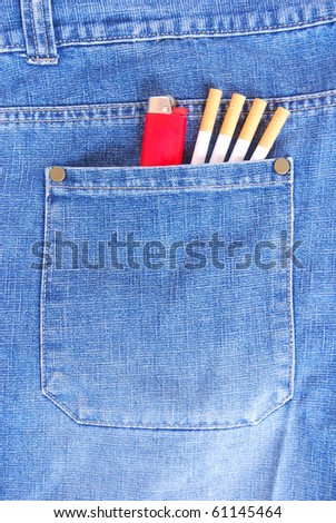 A big back pocket of a smoker\'s blue jeans with a red disposable plastic lighter and four filter cigarettes.
