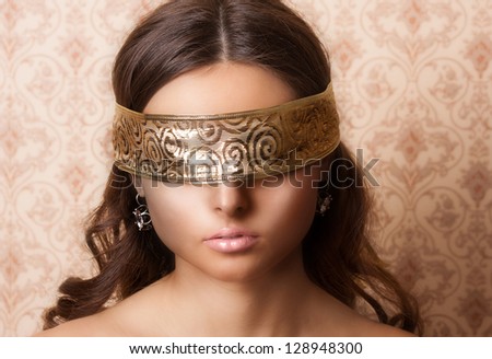 Mysterious beautiful face with ribbon on eyes