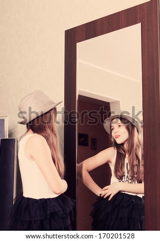beautiful funny teen girl looking in the mirror