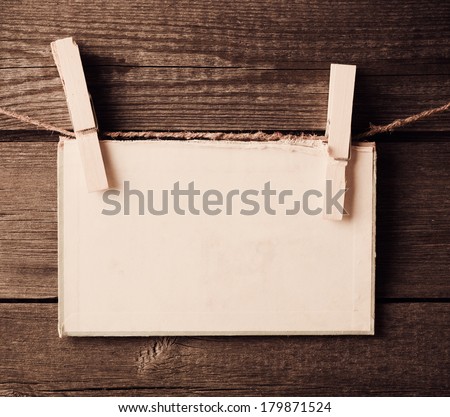 old paper attach to rope with clothes pins on wooden background