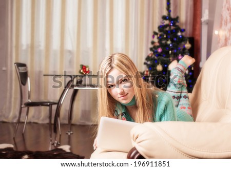 beautiful girl with laptop computer on background Christmas tree