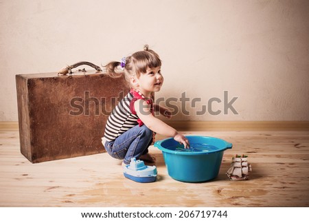 little child plays with toy and water indoor