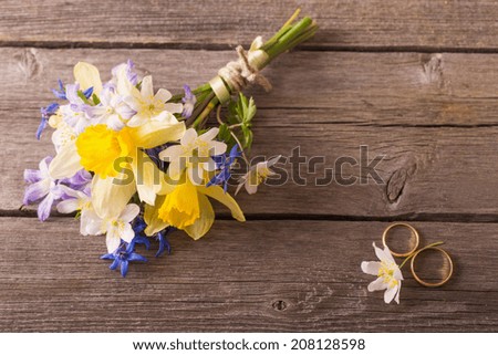 wedding bouquet with rings on wooden background
