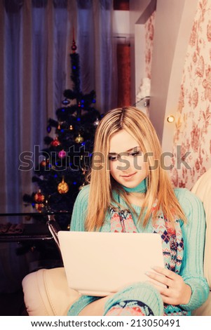 beautiful girl with laptop computer on background Christmas tree