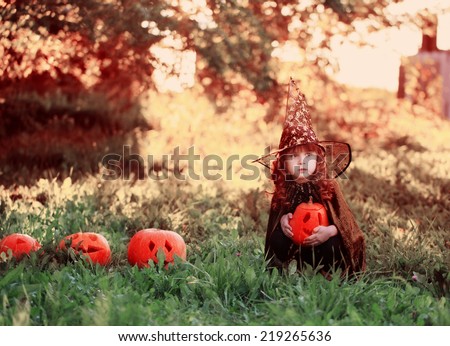 little girl in halloween costume with jack pumpkin
