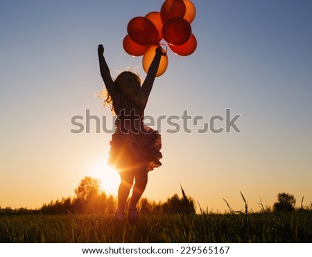 girl with balloons jumping outdoor