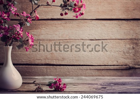 pink flowers in vase on wooden background