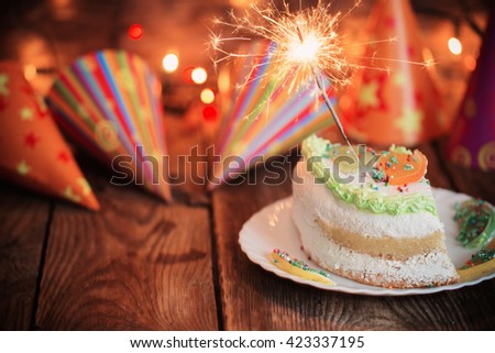 cake with sparkler on table on wooden background