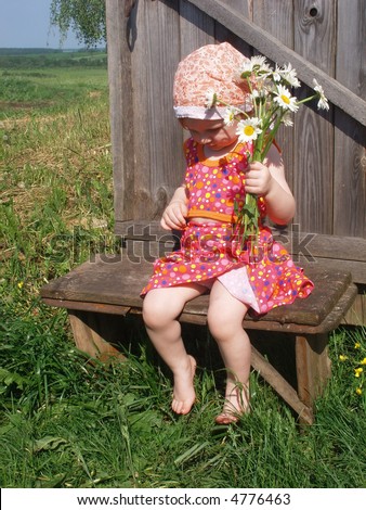 small girl with flowers on bench