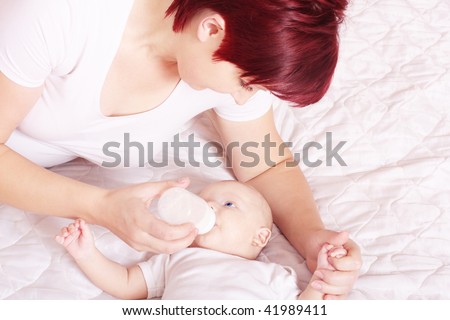Mother give drink her baby boy by feeding bottle