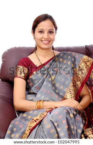 Happy young Indian woman sitting in sofa