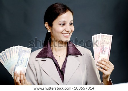 Young Indian business woman holding currency notes