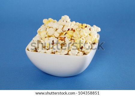 Delicious popcorn bowl on blue background
