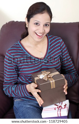 Excited young Indian woman with gift boxes