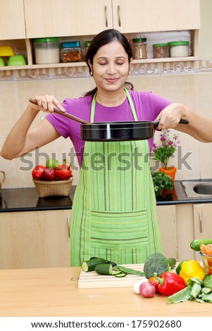 Young Indian woman preparing a dish in her kitchen