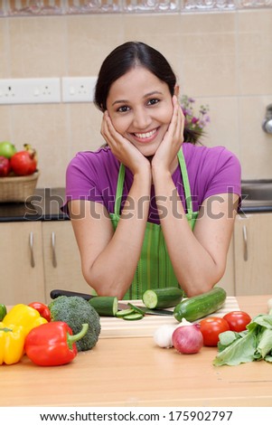 Beautiful young Indian woman in kitchen