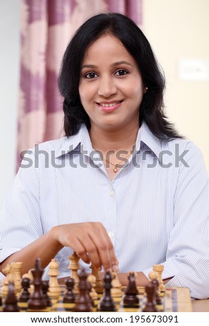 Happy young business woman playing chess