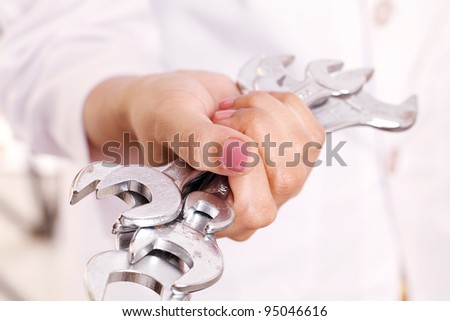 Hand holding various size spanners- Helping Hand