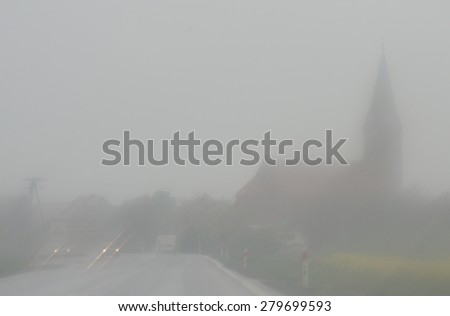 The city disappears in the fog and rain storm and it is difficult to drive a car.