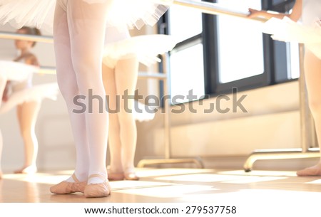 Young ballerinas wearing pointe shoes, the special reinforced satin shoes allowing a ballet dancer to stand on tip toe, low angle view of a class in progress