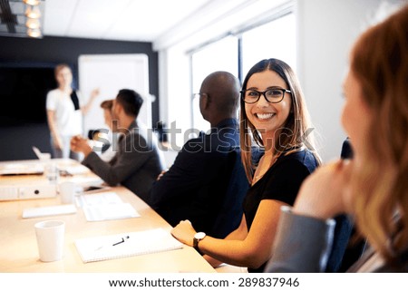 Female white executive smiling at camera during work presentation in office conference room
