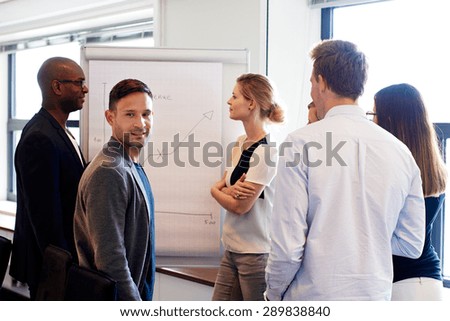 White male executive smiling at camera during work presentation