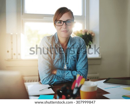 Successful business woman working at the office looking at camera