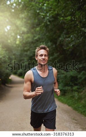 Three Quarter Shot of an Athletic Young Man Running at the Park in the Morning.