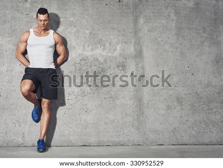 Fit and healthy man, muscular build portrait, fitness concept with copy space on grey background