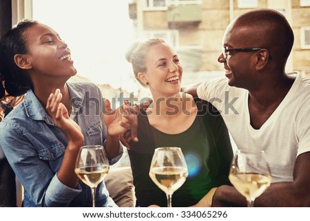 Group of multi ethnic friends drinking wine at a cafe outside