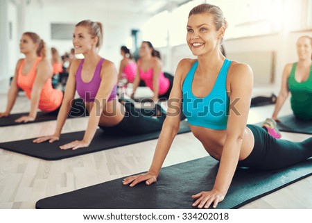 Group of attractive fit healthy young women working out in a class at the gym doing press-ups in a health and fitness concept