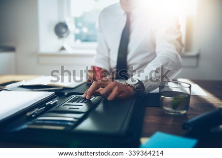 close up, business man or lawyer accountant working on accounts using a calculator and writing on documents