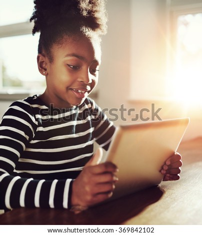 Close up Pretty Black Girl Playing Online Games on her Tablet Computer with Happy Facial Expression.