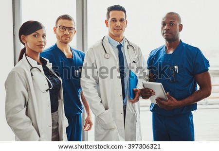 Multiracial team of doctors in a hospital standing in a corridor ready to make a ward round