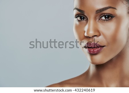 Beautiful young woman with perfect skin against a gray background