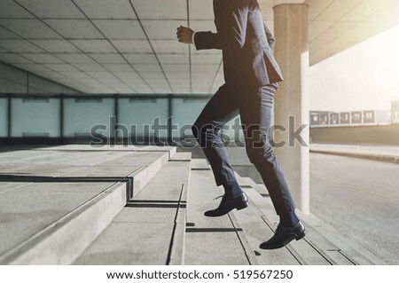 Businessman running fast upstairs. Horizontal outdoors shot.