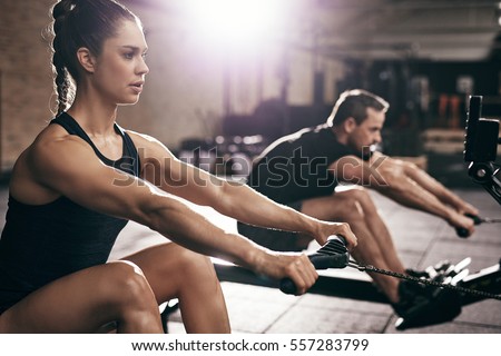 Sportive man and woman doing cardio training in gym. Horizontal indoors shot