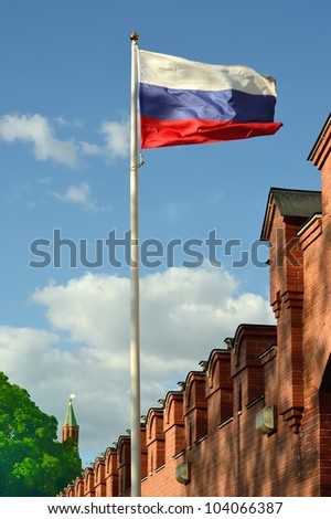The national flag of the Russian Federation against the background of the Kremlin wall