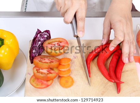 Image of woman holding knife to cut pepper prepare vegetables food for dinner