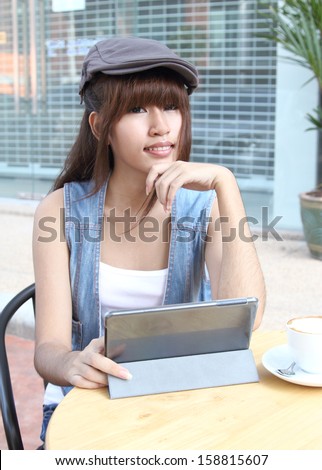 Image of asian student working her job with tablet at coffee shop